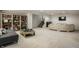 Finished basement featuring a cozy seating area, built-in bookshelves, and a staircase leading to the main level at 15679 Woodford Dr, Westfield, IN 46074