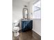 Stylish powder room with a navy blue vanity, gold accents, and hardwood floors at 15679 Woodford Dr, Westfield, IN 46074