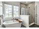 Bright bathroom featuring a freestanding tub, large windows, and a glass-enclosed shower with tiled walls at 15679 Woodford Dr, Westfield, IN 46074