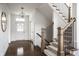 Inviting foyer featuring hardwood floors, a staircase with iron railings, and elegant light fixtures at 15679 Woodford Dr, Westfield, IN 46074