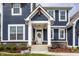 Close-up of a charming front porch with a white door, decorative wreath, and cozy seating area at 15679 Woodford Dr, Westfield, IN 46074