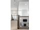 Open hallway with a view of the living room fireplace and staircase with metal railings at 15679 Woodford Dr, Westfield, IN 46074