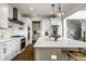 Island kitchen with white cabinets, stainless steel appliances, marble countertops, and a view of the eat in kitchen at 15679 Woodford Dr, Westfield, IN 46074