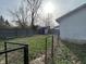 Fenced backyard featuring a grass area, shed, mature trees, and an open sky, perfect for outdoor activities at 1627 E 8Th St, Anderson, IN 46012