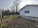 A fenced backyard with a small patio area, mature trees, and grass, providing privacy at 1627 E 8Th St, Anderson, IN 46012