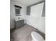 Bathroom featuring a gray vanity, tiled walls and laminate flooring, plus a modern toilet at 1627 E 8Th St, Anderson, IN 46012