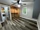 Empty bedroom with ample space, wood-look flooring, a ceiling fan, and custom shelving in closet at 1627 E 8Th St, Anderson, IN 46012
