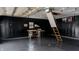 Spacious garage featuring a workbench, painted black paneled walls, and a ladder to the attic at 1627 E 8Th St, Anderson, IN 46012