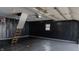 Finished garage featuring black paneled walls, epoxy flooring, and attic access at 1627 E 8Th St, Anderson, IN 46012