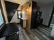Small kitchen with wood paneled accent wall, wood-look flooring, modern fixtures, and dark appliances at 1627 E 8Th St, Anderson, IN 46012