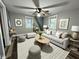 Bright living room with modern gray furniture, wood-look flooring, ceiling fan, and natural lighting at 1627 E 8Th St, Anderson, IN 46012