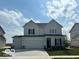 Inviting two-story home with a three-car garage, neutral siding, black shutters and a manicured lawn at 16441 Mount Logan Rd, Noblesville, IN 46060