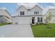 Charming two-story home boasts a three car garage and meticulously manicured lawn at 16441 Mount Logan Rd, Noblesville, IN 46060