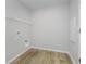 Spacious laundry room with shelving and wood-look flooring at 16441 Mount Logan Rd, Noblesville, IN 46060