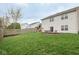 Well-kept backyard with a lush lawn, a cozy fire pit, and a fun play set at 16963 Southall Dr, Westfield, IN 46074