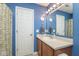Bright blue bathroom featuring a vanity with mirror and a shower with patterned curtain at 16963 Southall Dr, Westfield, IN 46074