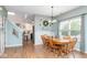 Dining room with hardwood floors, light blue walls with white trim, bright lighting, and an attached kitchen at 16963 Southall Dr, Westfield, IN 46074