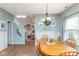 Dining room with hardwood floors, light blue walls with white trim, bright lighting, and an attached kitchen at 16963 Southall Dr, Westfield, IN 46074
