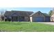 Charming single-story brick home with an attached three-car garage and covered porch situated on a well-manicured lawn at 1915 Barbie Ct, Franklin, IN 46131