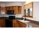 A kitchen with wood cabinets, a stainless steel sink, and black appliances at 1915 Barbie Ct, Franklin, IN 46131