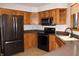 A kitchen featuring wood cabinets, black appliances, and gray countertops at 1915 Barbie Ct, Franklin, IN 46131