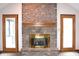 Living room showcases a brick fireplace flanked by doors, complemented by plush carpeting and neutral decor at 1915 Barbie Ct, Franklin, IN 46131