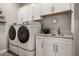 Functional laundry room equipped with modern washer, dryer, sink and plenty of storage at 19668 Mcdonald Pl, Westfield, IN 46074