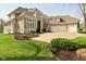 Well-maintained home featuring a sprawling lawn, mature landscaping, and an attached three-car garage at 2004 Caledonian Ct, Greenwood, IN 46143