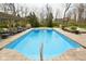 Sparkling swimming pool surrounded by lounge chairs, lush landscaping, and a relaxing pergola at 2004 Caledonian Ct, Greenwood, IN 46143
