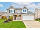 Traditional two-story home featuring a two-car garage, manicured lawn and inviting landscaping at 20107 Marie Ct, Noblesville, IN 46062