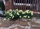 The garden bed features vibrant yellow daffodils, set against a backdrop of natural stone and wooden deck trim at 20107 Marie Ct, Noblesville, IN 46062