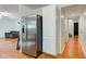 Hallway adjacent to the stainless steel refrigerator with wood flooring and white paint and cabinetry at 20107 Marie Ct, Noblesville, IN 46062