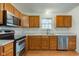 Well-lit kitchen featuring stainless steel appliances, light countertops, ample wood cabinetry, and a window over the sink at 20107 Marie Ct, Noblesville, IN 46062