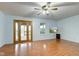 Inviting living room featuring wood flooring, a ceiling fan, and double glass doors that lead to a patio at 20107 Marie Ct, Noblesville, IN 46062