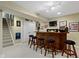 A well-lit basement bar featuring a wooden bar, stools, decorations and a TV at 203 Winslow Dr, Westfield, IN 46074