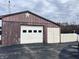 Detached garage with a white door and parking space, located at the back of the house at 204 W Berry St, Alexandria, IN 46001