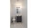 Clean and functional bathroom featuring a vanity with storage, a well-lit mirror, and marble-look floors at 2134 Dawson St, Indianapolis, IN 46203