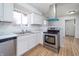 Modern kitchen featuring stainless steel appliances, white cabinets, new countertops, and stylish wood-look flooring at 2134 Dawson St, Indianapolis, IN 46203