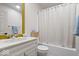 Bathroom with white vanity, shower with curtain, and gold mirror accent at 2349 N Delaware St, Indianapolis, IN 46205