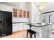 Light kitchen with white cabinetry, black appliances, and island with bar seating at 2349 N Delaware St, Indianapolis, IN 46205