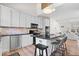 Bright kitchen features stone backsplash, stainless appliances, black countertops, and an island with stools at 2349 N Delaware St, Indianapolis, IN 46205