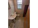 Modest bathroom features a pedestal sink, classic black and white tile floor, and natural light from the window at , Indianapolis, IN 46220