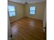 Empty bedroom with hardwood floors, neutral paint, and plenty of natural light from the two windows at , Indianapolis, IN 46220