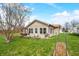 Spacious backyard with a covered patio, lush green grass, and surrounded by mature trees under a bright, sunny sky at 301 Lancelot Dr, Franklin, IN 46131