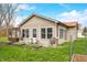 Backyard featuring a covered patio, lush green grass, surrounded by garden beds and mature trees under a bright sky at 301 Lancelot Dr, Franklin, IN 46131