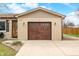Close-up of a brick home featuring a double garage door, decorative lighting, and a charming front entrance at 301 Lancelot Dr, Franklin, IN 46131