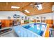 Indoor pool with a retractable cover, a wood ceiling, and multiple windows for natural light at 301 Lancelot Dr, Franklin, IN 46131