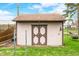 A backyard shed with double doors and neutral siding provides extra outdoor storage at 301 Lancelot Dr, Franklin, IN 46131