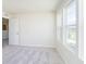 Bright bedroom showcasing large windows, plush carpeting, and easy access to the hallway at 3241 Fawn Cir, Brownsburg, IN 46112