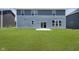 Exterior back of home with blue siding, green lawn, and sliding glass door at 3241 Fawn Cir, Brownsburg, IN 46112